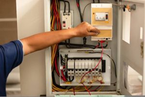 electrician in Cairns working on a breaker box